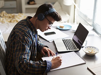 young man sitting in front of a laptop